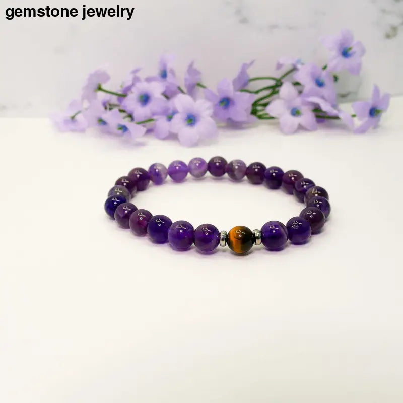 Amethyst and Tiger Eye stretch bracelet with sterling silver spacers and purple flowers in the background.